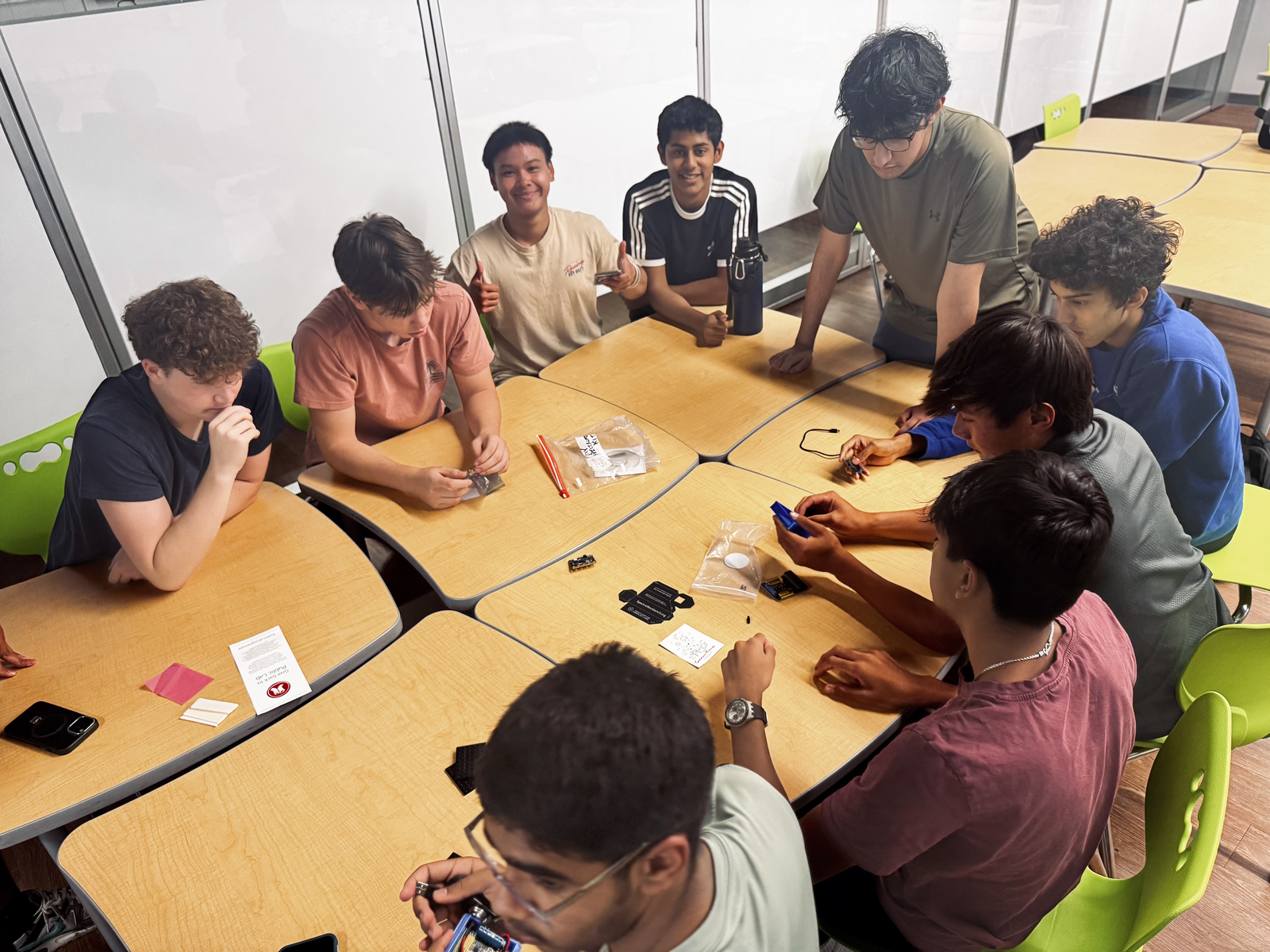 En4AC members assembling electronics together around classroom tables